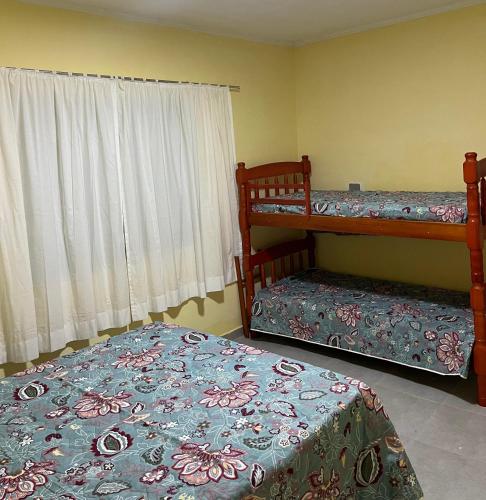 a bedroom with two bunk beds and a window at Apto. em Conceição dos Ouros MG in Conceição dos Ouros