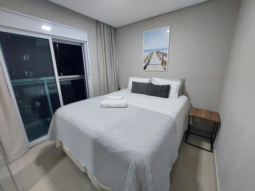 a bedroom with a large white bed with a window at Book Santos - Estanconfor 708 - 2 quartos in Santos