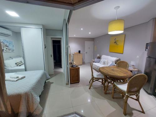 a bedroom with a bed and a table and a dining room at Book Santos - Estanconfor 708 - 2 quartos in Santos