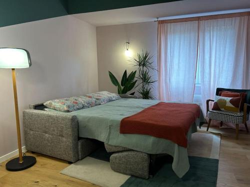 um quarto com uma cama, um candeeiro e uma cadeira em Luxury Loft Marghera em Milão