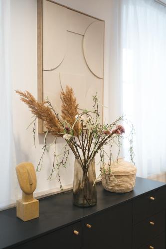 a black dresser with a vase with flowers on it at Penzion Weber in Český Krumlov