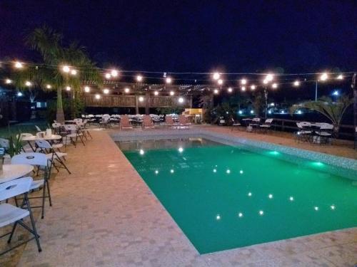 una piscina con tavoli e sedie di notte di Hotel Fazenda Estancia do Lago a Guapirama