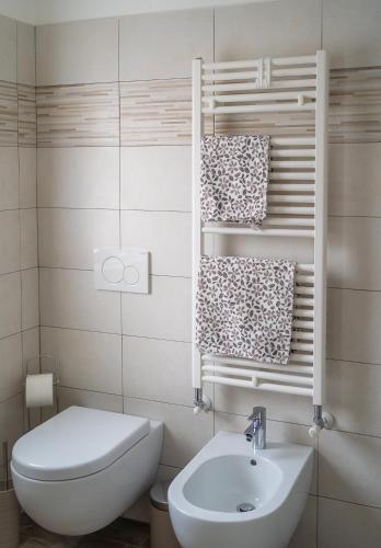 a bathroom with a sink and a toilet and towels at Dolce Lago B&B in Calolziocorte