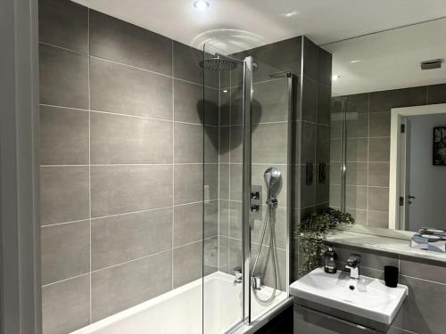 ein Bad mit einer Dusche und einem Waschbecken in der Unterkunft Luxury Oaks Suite, Free private parking, 2 Bed 2 Bathroom Apartment, Central location in Birmingham