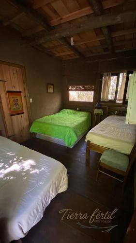 a room with two beds in a cabin at Tierra Fértil Eco Posada in Santa Ana