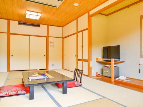 a living room with a table and a tv at Fudouonsen Sawaya in Shimojo mura
