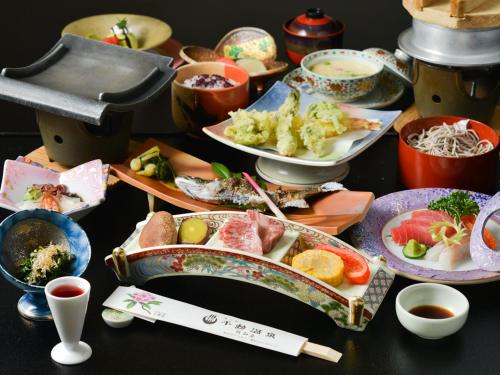 a table topped with plates of food with chopsticks and bowls at Fudouonsen Sawaya in Shimojo mura
