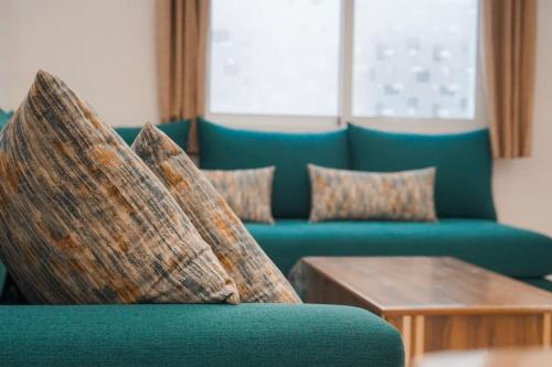 a living room with a blue couch and a table at Appartement Chic et Luxueux Corniche Tanger in Tangier