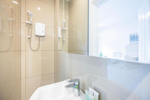 Private Room with Private Bathroom Croydon في كرويدون: حمام أبيض مع حوض ودش