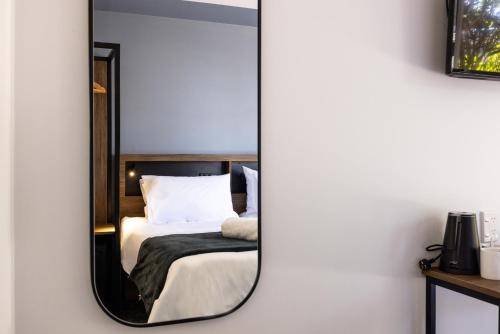 a mirror reflecting a bed in a bedroom at Haka House Rotorua in Rotorua