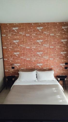 a bedroom with a brick wall and a bed at Manila House - private garage - Milan IEO Humanitas in Locate di Triulzi