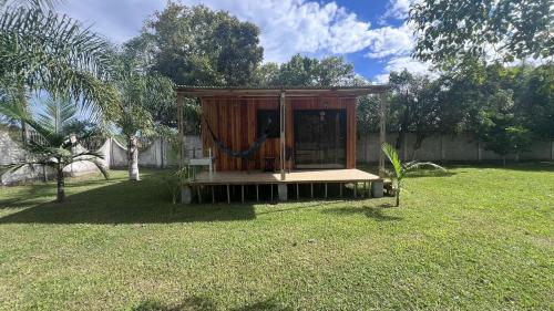 a wooden out house with a hammock in a yard at Chacara Recanto do Pinheiro in Capão do Leão