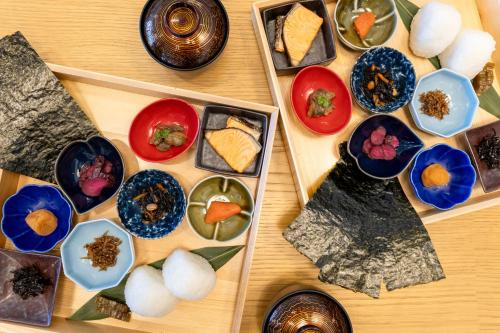 a wooden table with plates of food on it at OND HOTEL（オンドホテル） in Takeo