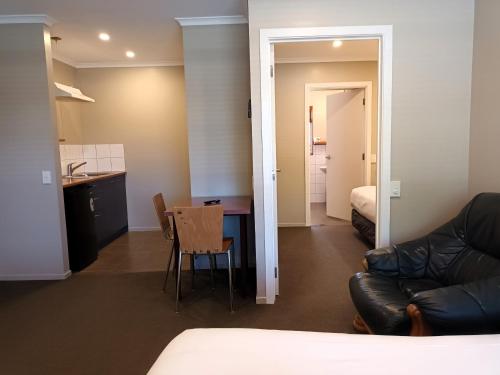 a room with a couch and a table and a kitchen at Tongariro Junction Accommodation in Turangi
