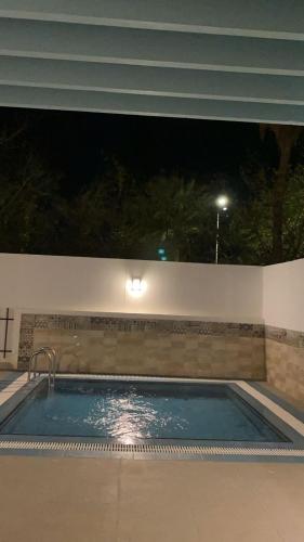 een zwembad 's nachts met de lichten aan bij جولدن شاليه in Madīnat Yanbu‘ aş Şinā‘īyah