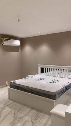 een slaapkamer met een bed met een wit bedframe bij جولدن شاليه in Madīnat Yanbu‘ aş Şinā‘īyah
