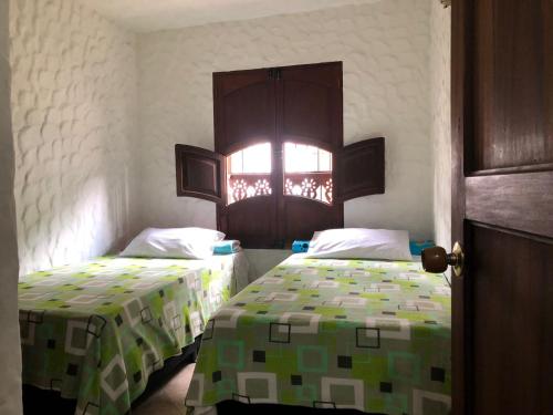 a bedroom with two beds and a window at CASA HOSPEDAJE PRANA in Jardin