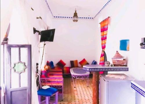 a colorful living room with a couch and chairs at Dar tisir in Essaouira