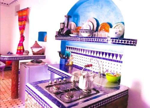 a kitchen with a stove with a tea kettle on it at Dar tisir in Essaouira