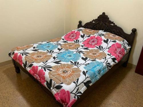 Bett in einem Zimmer mit Blumenmuster in der Unterkunft Adventurer's Vacation Home in Alaminos