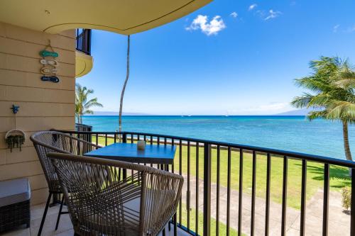 un balcon avec une table et des chaises et l'océan dans l'établissement Kahana Reef #216, à Kahana