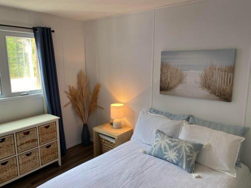 um quarto com uma cama branca e uma janela em La Belle Nature em Saint Ludger de Milot