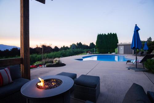 a patio with a fire pit next to a pool at Crawford View in Kelowna