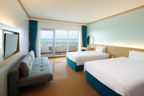 a hotel room with two beds and a view of the ocean at Saipan World Resort in Susupe