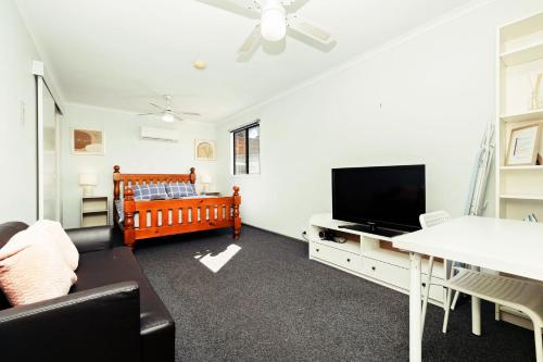 sala de estar con cuna y TV en 1 BR Granny Flat near Airport en West Richmond