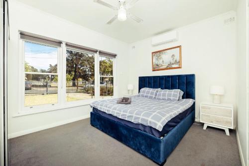 um quarto com uma cama azul e uma janela em 3 BR House Near Airport em West Richmond