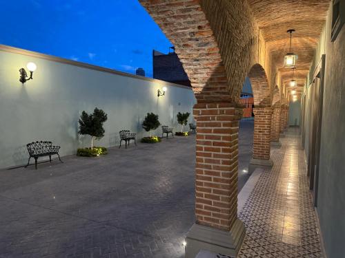 a brick pillar in a courtyard with benches at Hotel Posada Real in Lagos de Moreno