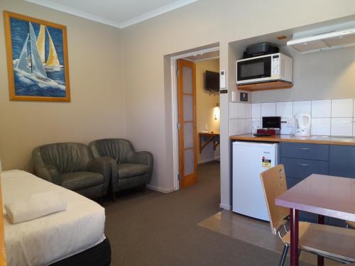 a room with a kitchen and a living room with a bed at Tongariro Junction Accommodation in Turangi