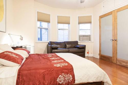 a bedroom with a bed and a couch at Spacious Passyunk Square 3BR House in Philadelphia