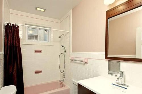 Spacious Passyunk Square 3BR House في فيلادلفيا: حمام مع مرحاض بالوعة ومرآة