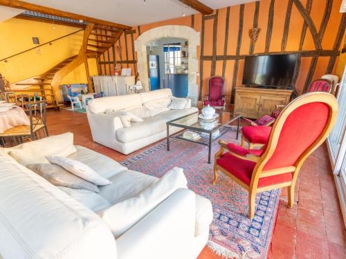 Il comprend un salon doté d'un mobilier blanc et d'une télévision. dans l'établissement Grand Gîte à Louvemont : 8 Chambres, Piscine Chauffée, Proche Lac et Activités outdoor - FR-1-611-69, à Louvemont