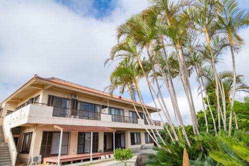 una vista exterior de una casa con palmeras en さつきあん, en Isla Miyako