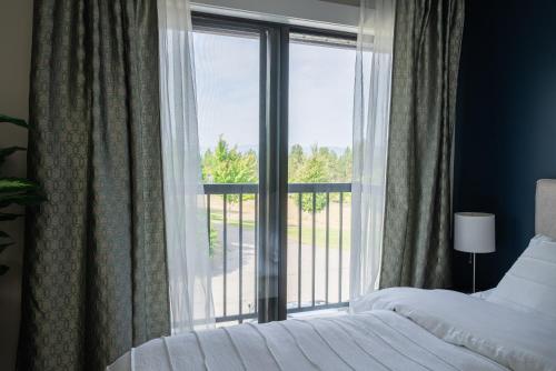 a bedroom with a bed and a large window at Crawford View in Kelowna