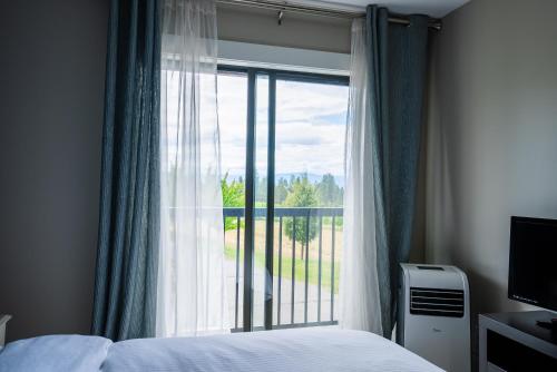 a bedroom with a bed and a large window at Crawford View in Kelowna