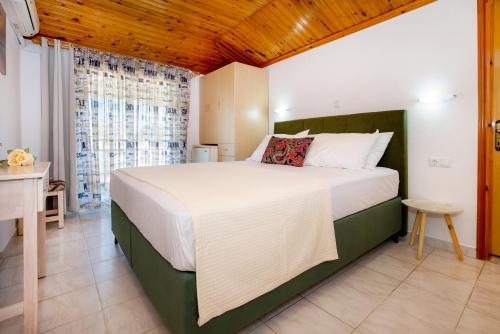 a bedroom with a large bed and a desk at Kalogeraki Studios in Potos