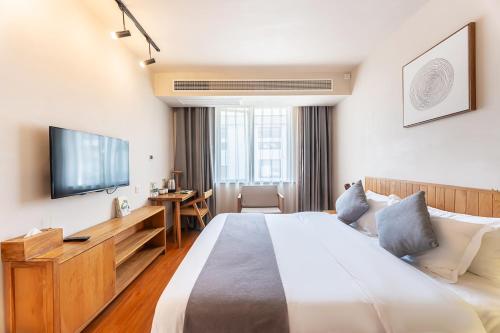 a hotel room with a large bed and a television at Hangzhou Yueshang Yunshe Boutique Hostel in Hangzhou