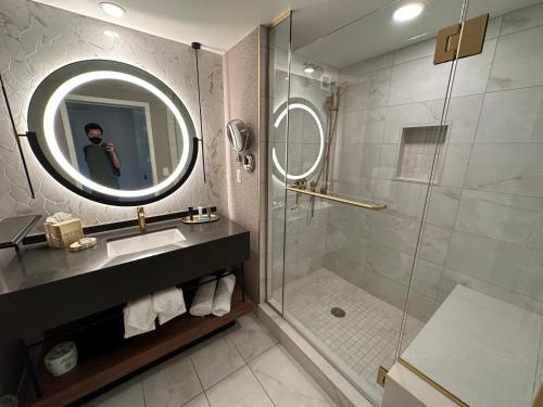 a man taking a picture of a bathroom with a shower at Cozy Unit by Caesars Atlantic City in Atlantic City