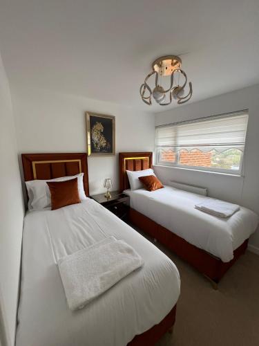 a bedroom with two beds and a window and a chandelier at Elegant House in Barnstaple