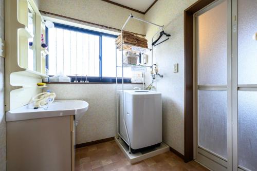 ein kleines Bad mit einem Waschbecken und einem Fenster in der Unterkunft taiza house in Kyōtango
