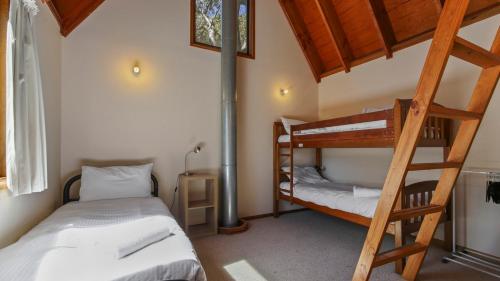 a bedroom with two bunk beds and a ladder at Deep Powder in Dinner Plain