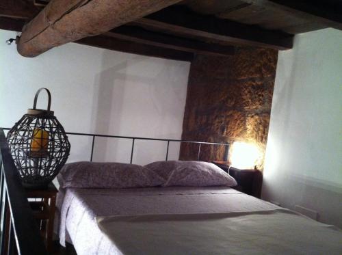 a bedroom with a bed and a stone wall at Casalio in Barbarano Romano