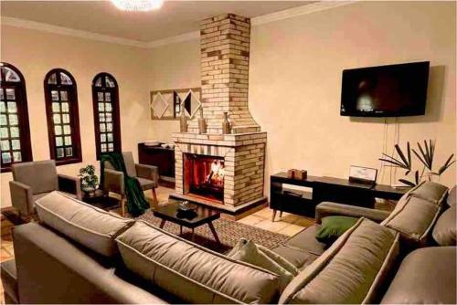 - un salon avec un canapé et une cheminée dans l'établissement Café com chocolate, à Piedade