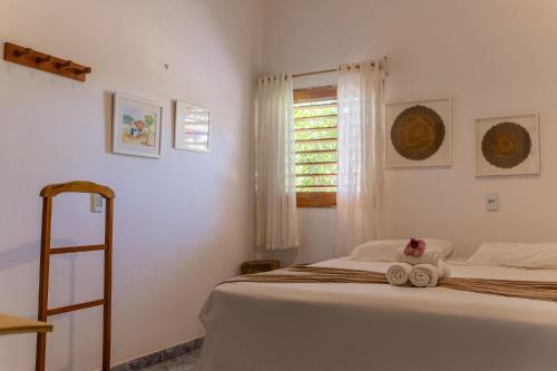 a bedroom with a bed with two towels on it at Pousada Chez Ellery Jeri in Jericoacoara