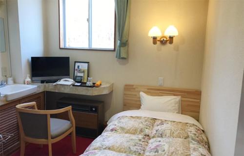 a bedroom with a bed and a desk and a sink at Musashibou in Hiraizumi