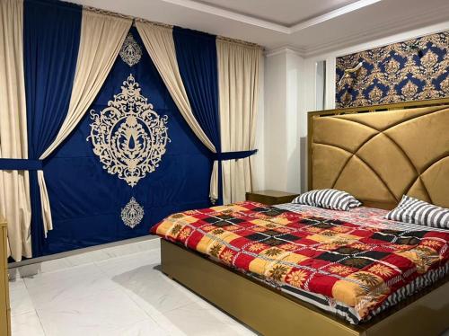 ein Schlafzimmer mit einem Bett in Blau und Gold in der Unterkunft 2 bhk apartment available in Al qasmiyah Sharjah in Schardscha