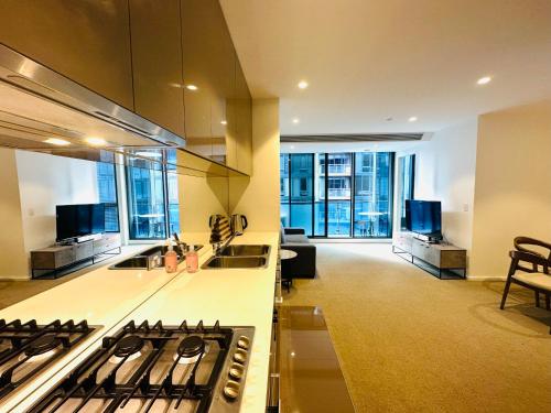 a kitchen with a stove and a living room at The Southbank Central Retreat in Melbourne